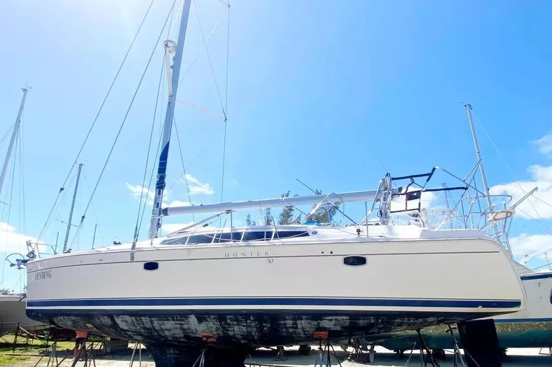 Pending Yacht Photos Pics Hunter Aft Cockpit 50 sailboat, 2012 model, on land under clear blue sky.