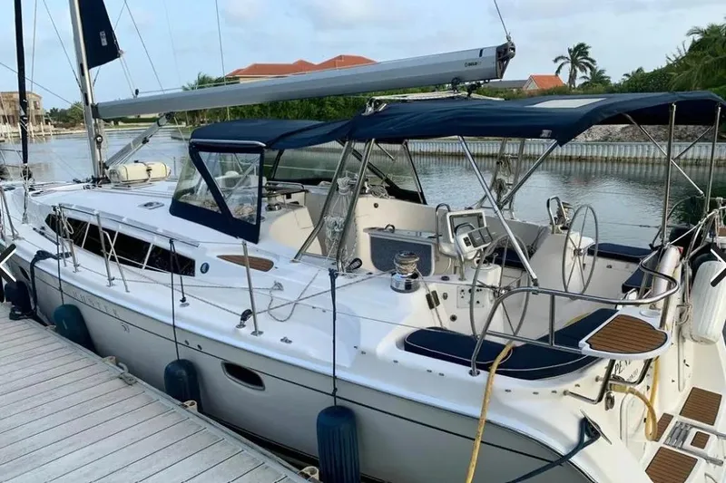 Pending Yacht Photos Pics Hunter Aft Cockpit 50 sailboat, 2012 model, docked by a serene waterfront.