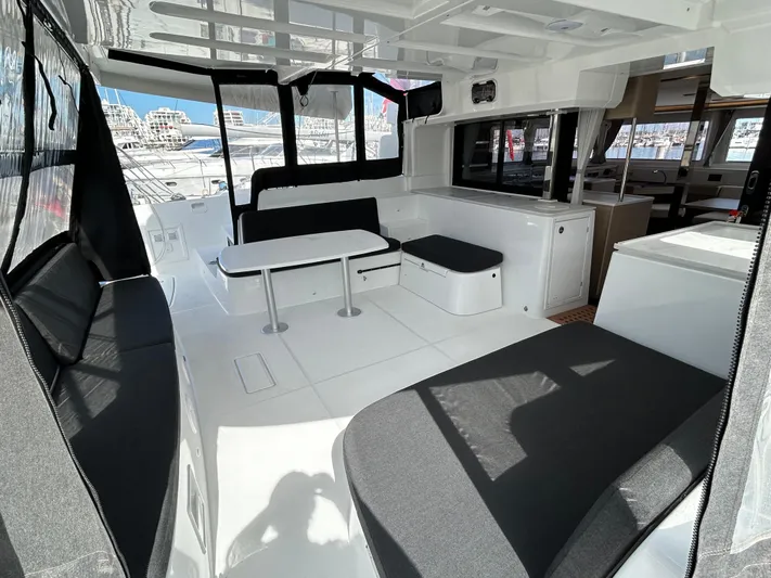 Yacht Photos Pics 2024 Lagoon 46 yacht interior with modern seating and dining area, featuring sleek design and ample natural light.