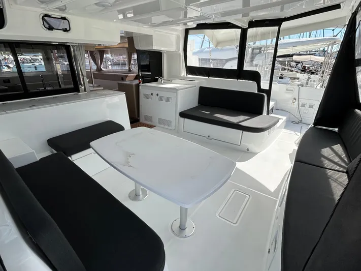  Yacht Photos Pics 2024 Lagoon 46 yacht interior with modern seating and table, featuring sleek design and ample natural light.