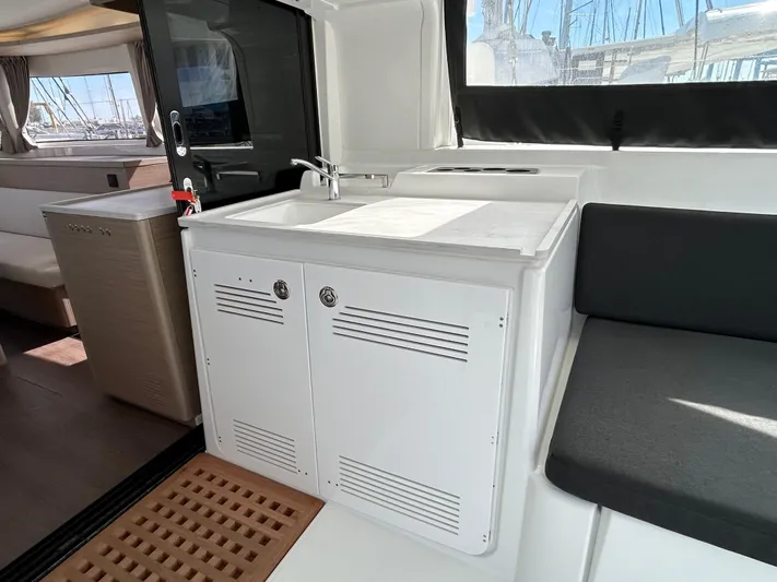  Yacht Photos Pics 2024 Lagoon 46 yacht interior with kitchenette and seating area.