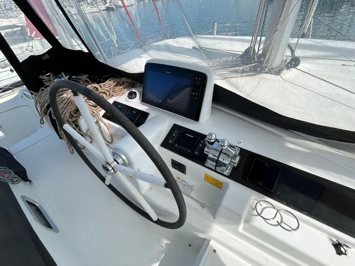  Yacht Photos Pics Helm station of 2024 Lagoon 46 catamaran with steering wheel and navigation controls.