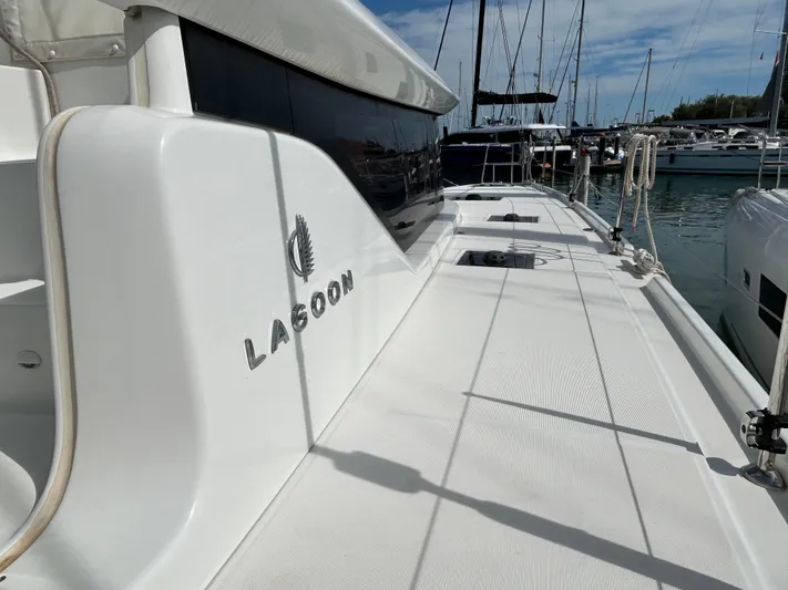  Yacht Photos Pics 2024 Lagoon 46 catamaran docked at marina, showcasing sleek deck design.