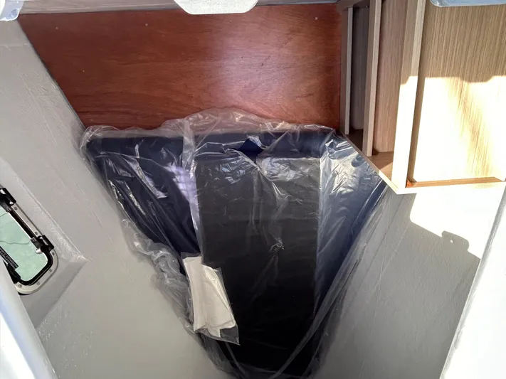  Yacht Photos Pics 2024 Lagoon 46 interior detail with plastic-covered cushion and wooden accents.