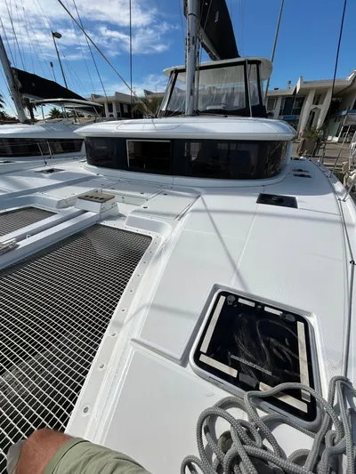  Yacht Photos Pics 2024 Lagoon 46 catamaran deck with ropes and netting under a clear blue sky.