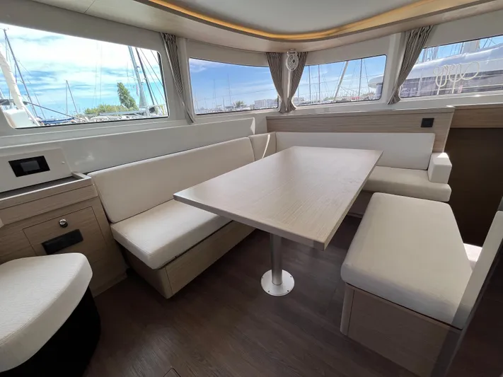  Yacht Photos Pics 2024 Lagoon 46 yacht interior with elegant dining area and panoramic windows.