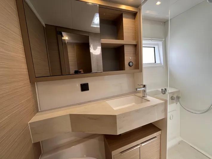  Yacht Photos Pics Modern bathroom in 2024 Lagoon 46 yacht with sleek sink, mirror, and storage.