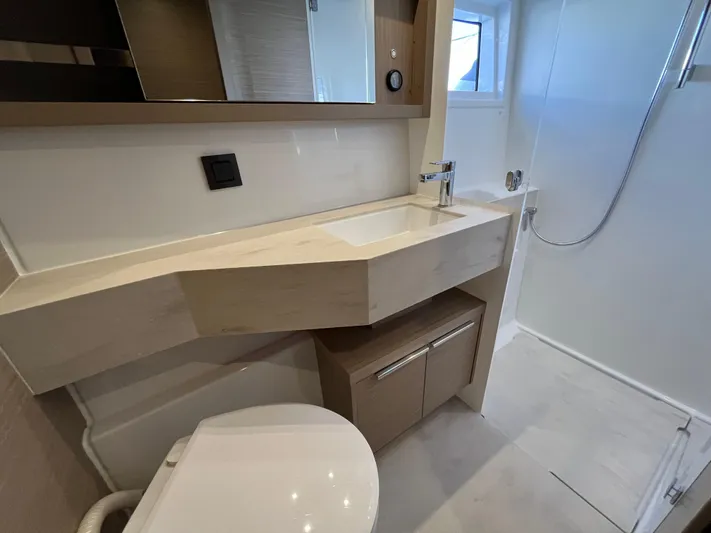  Yacht Photos Pics 2024 Lagoon 46 yacht bathroom with modern sink, shower, and toilet.