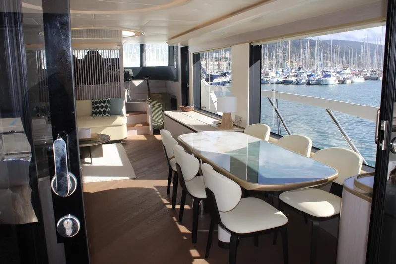  Yacht Photos Pics Luxurious interior of 2025 Absolute NAVETTA 70 yacht with elegant dining area and marina view.