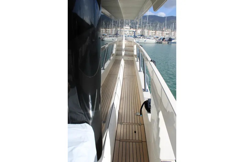  Yacht Photos Pics Side deck of 2025 Absolute NAVETTA 70 yacht, featuring sleek design and marina view.