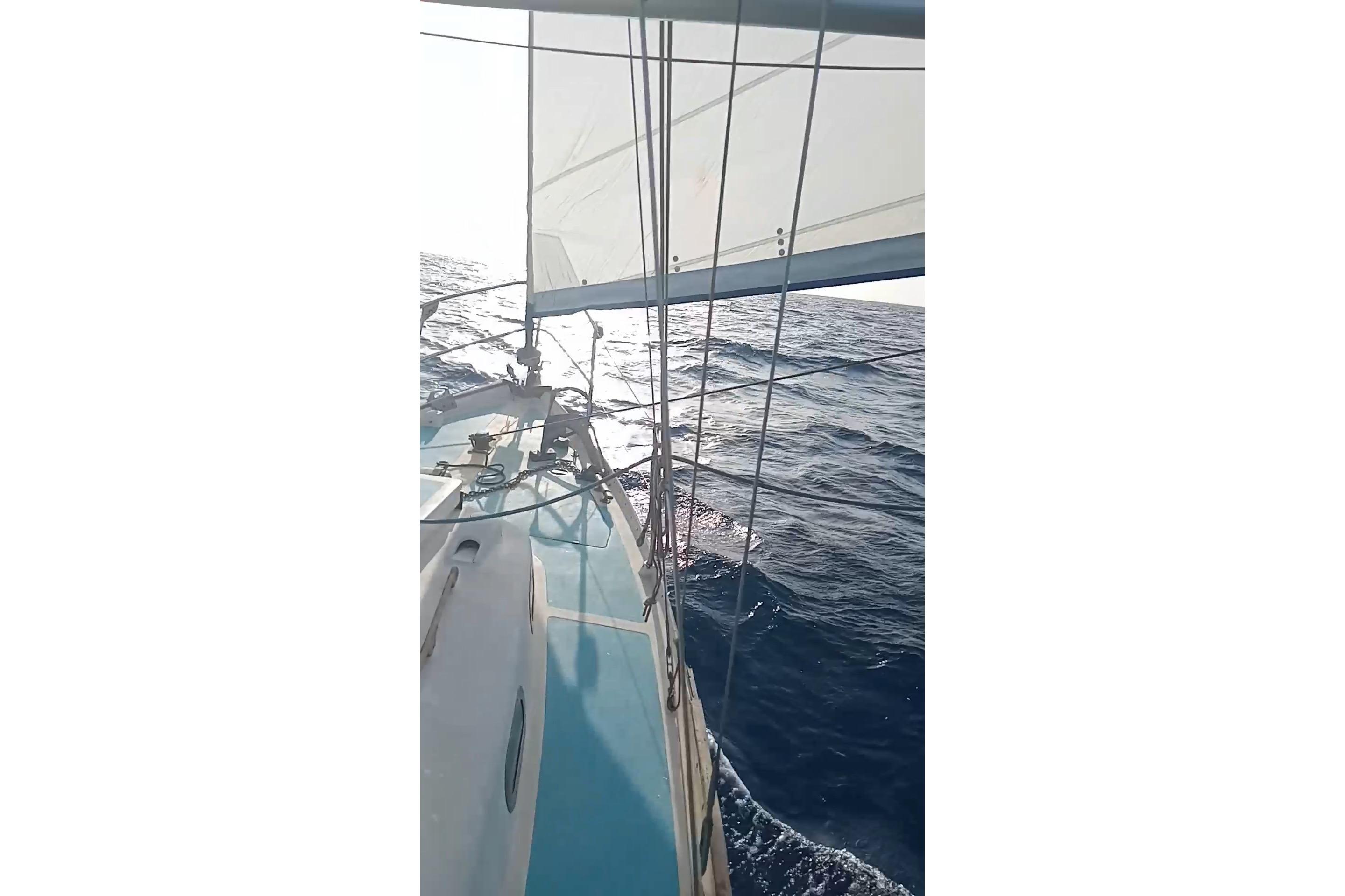 Sailing on a 1965 Nicholson 32 yacht, gliding through open sea under clear skies.