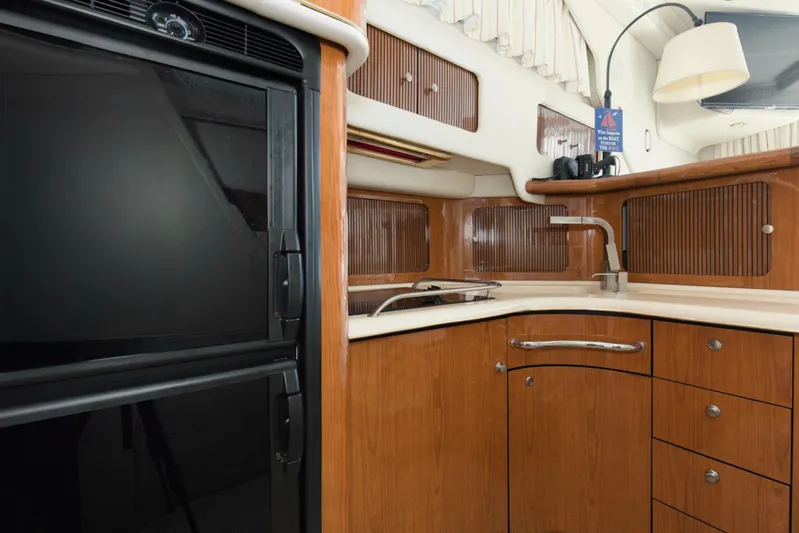 Silver Lining Yacht Photos Pics Interior of 2000 Sea Ray 400 Sedan Bridge yacht kitchen with wood cabinetry and appliances.