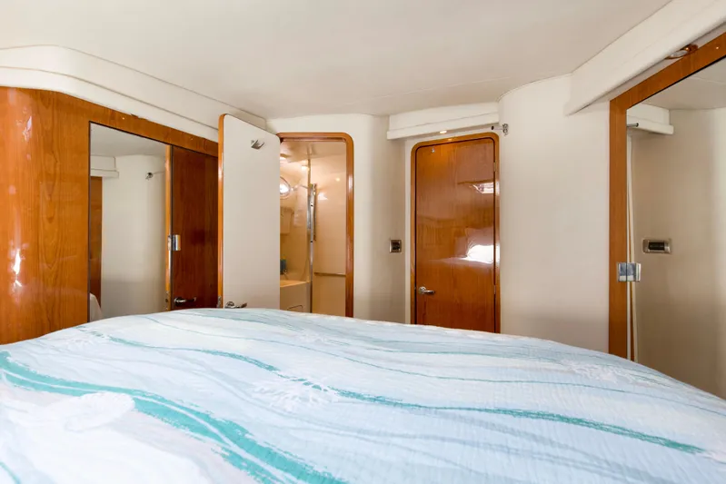 Silver Lining Yacht Photos Pics Interior of 2000 Sea Ray 400 Sedan Bridge, featuring a cozy bedroom with wooden accents.