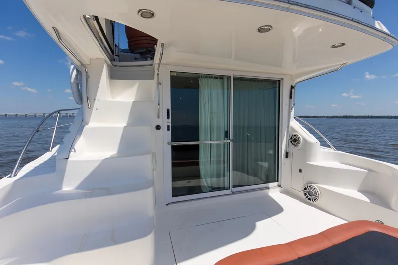 Silver Lining Yacht Photos Pics 2000 Sea Ray 400 Sedan Bridge yacht deck with sliding glass door and ocean view.