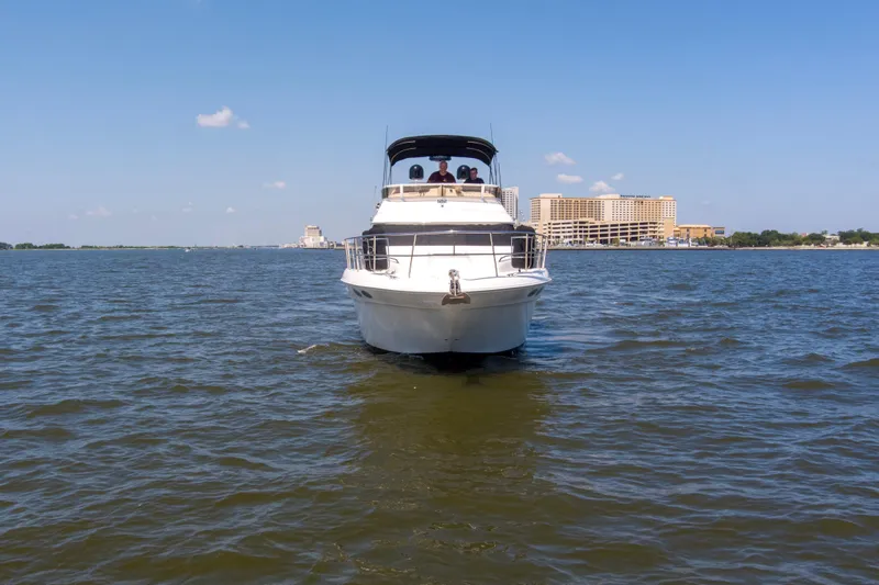 Silver Lining Yacht Photos Pics 2000 Sea Ray 400 Sedan Bridge yacht on open water with cityscape background.