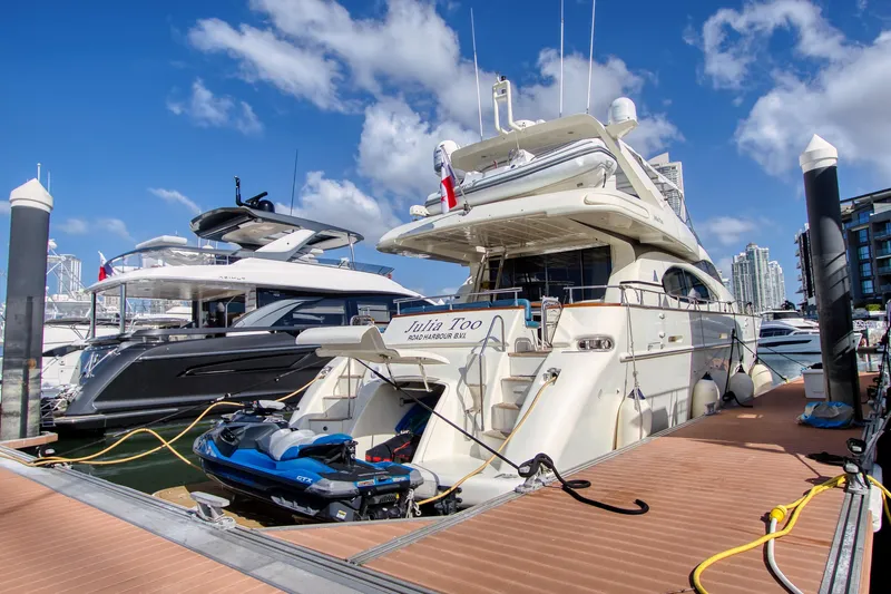 Julia Too Yacht Photos Pics Luxury 2002 Azimut 70 Sea Jet yacht docked with jet ski, under clear blue sky.