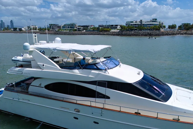 Julia Too Yacht Photos Pics Azimut 70 Sea Jet 2002 yacht on calm waters with modern buildings in the background.
