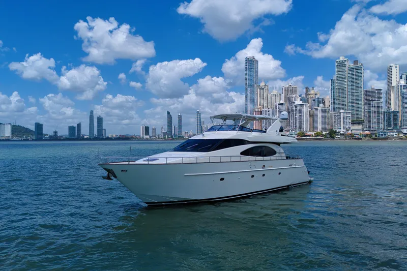 Julia Too Yacht Photos Pics Azimut 70 Sea Jet yacht cruising near a city skyline under a blue sky.