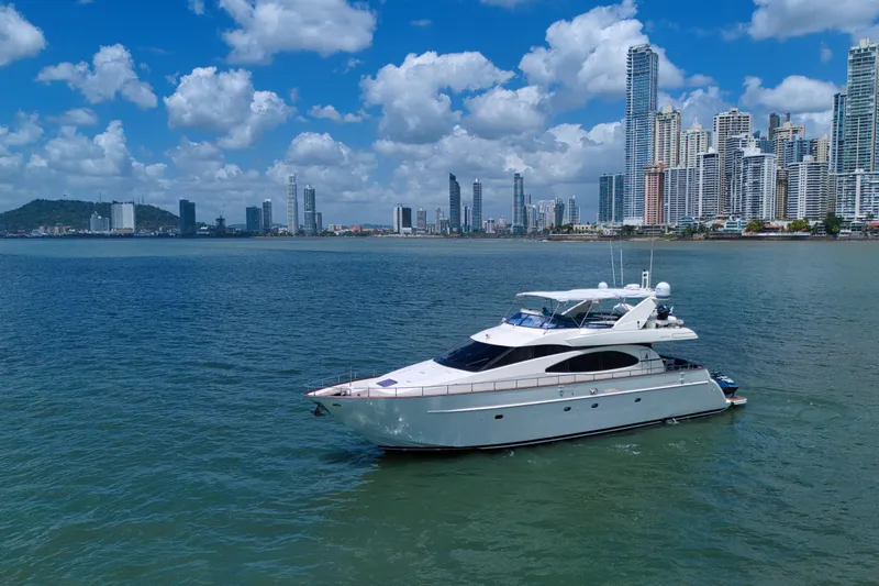 Julia Too Yacht Photos Pics Luxury 2002 Azimut 70 Sea Jet yacht cruising near a city skyline under blue skies.