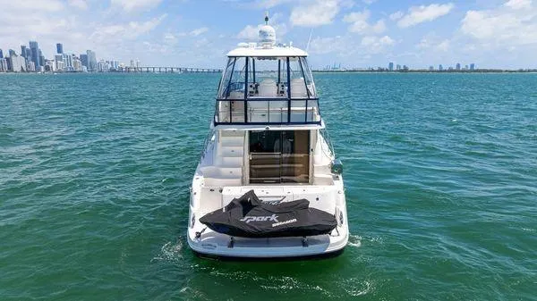  Yacht Photos Pics 2005 Sea Ray 52 Sedan Bridge yacht on open water, city skyline in background.