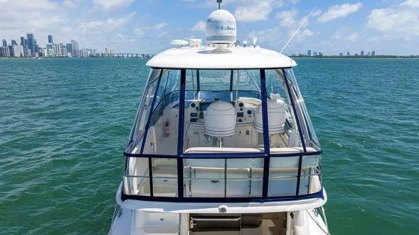  Yacht Photos Pics 2005 Sea Ray 52 Sedan Bridge yacht on open water with city skyline.
