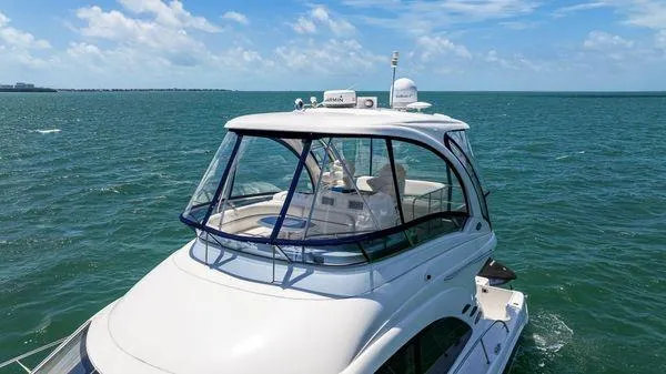  Yacht Photos Pics 2005 Sea Ray 52 Sedan Bridge yacht cruising on open water under a clear blue sky.