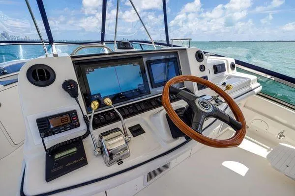  Yacht Photos Pics 2005 Sea Ray 52 Sedan Bridge helm with navigation screens and wooden steering wheel.