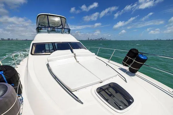  Yacht Photos Pics 2005 Sea Ray 52 Sedan Bridge yacht cruising on turquoise waters under a clear blue sky.