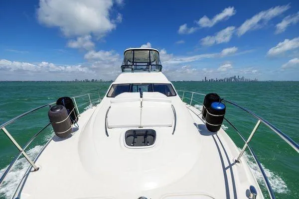  Yacht Photos Pics 2005 Sea Ray 52 Sedan Bridge yacht cruising on open water under a clear blue sky.