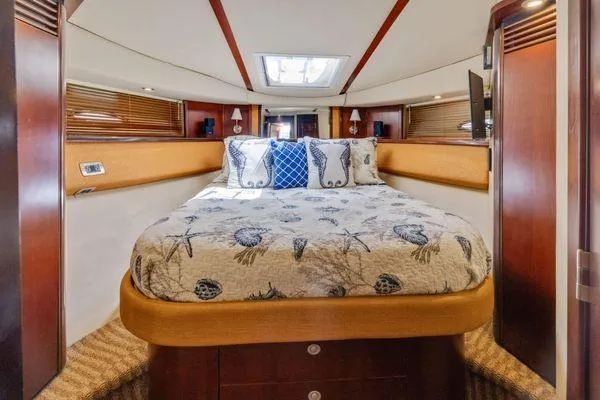  Yacht Photos Pics Luxurious bedroom interior of 2005 Sea Ray 52 Sedan Bridge yacht with nautical-themed bedding.