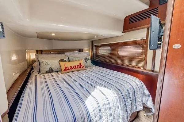  Yacht Photos Pics Luxurious bedroom in 2005 Sea Ray 52 Sedan Bridge yacht with striped bedding and "beach" pillow.