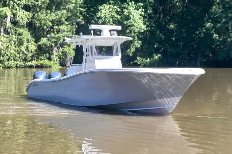  Yacht Photos Pics 2011 Yellowfin 36 Offshore boat cruising on a calm river, surrounded by lush greenery.