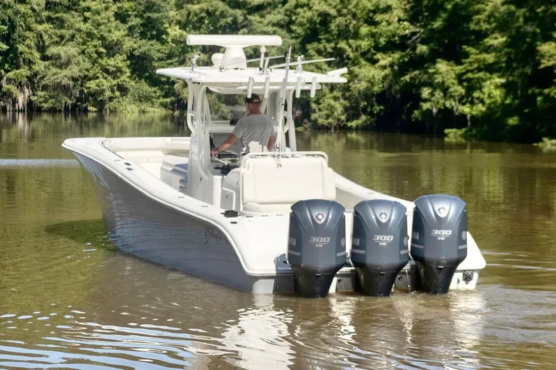  Yacht Photos Pics 2011 Yellowfin 36 Offshore boat with triple outboard engines on a calm river.