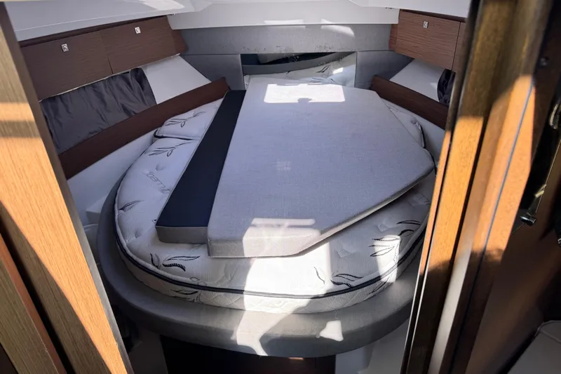  Yacht Photos Pics 2019 Jeanneau NC 895 cabin interior with cozy bed and wooden accents.