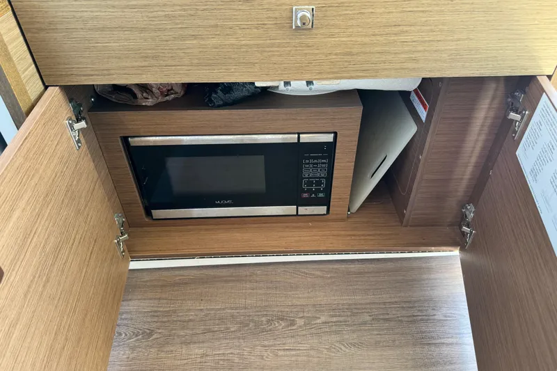  Yacht Photos Pics 2019 Jeanneau NC 895 interior with built-in microwave in wooden cabinet.