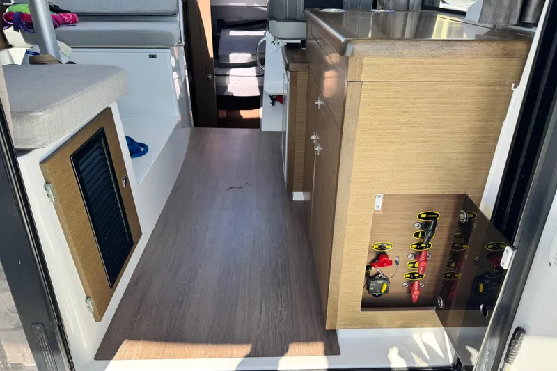  Yacht Photos Pics Interior view of 2019 Jeanneau NC 895 boat, featuring wood cabinetry and seating.