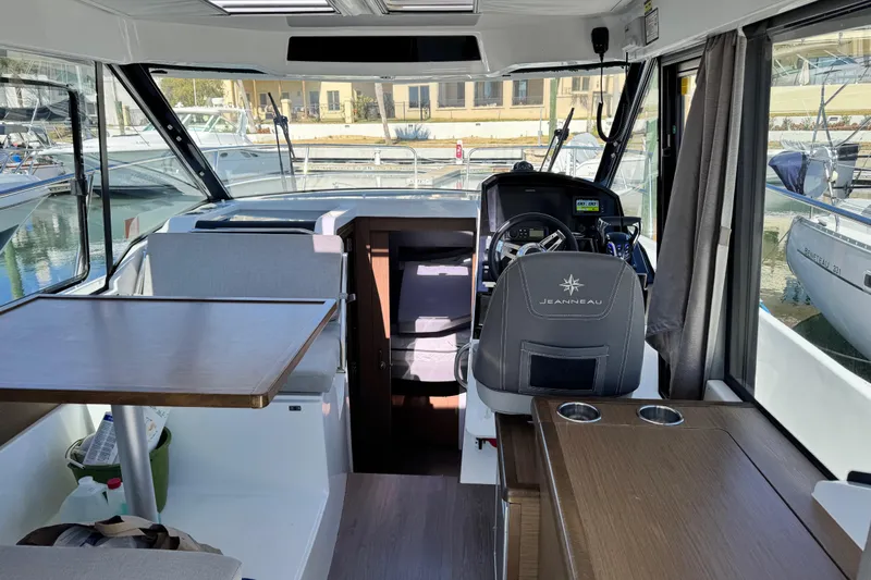  Yacht Photos Pics Interior of 2019 Jeanneau NC 895 boat with helm, seating, and table.