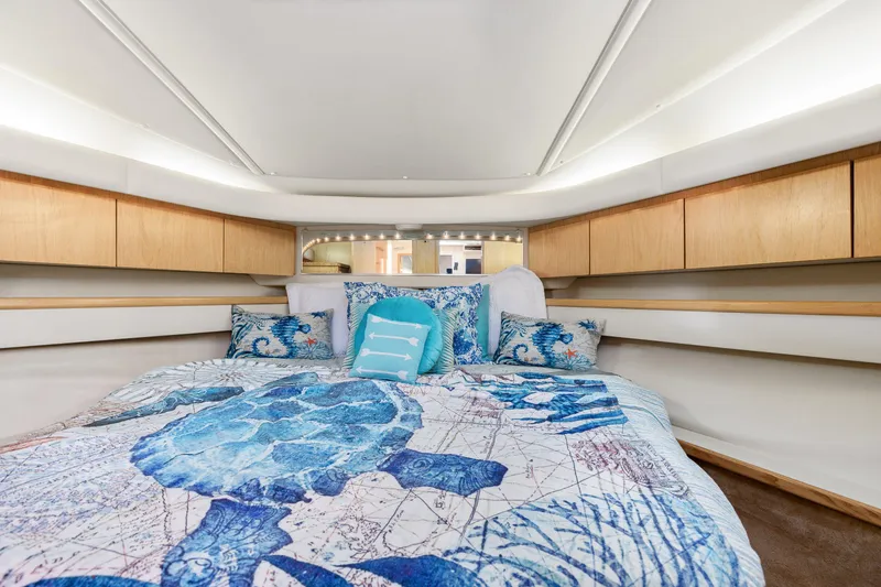  Yacht Photos Pics 1999 Tiara Yachts 4000 Express cabin with turtle-themed bedding and wooden storage cabinets.