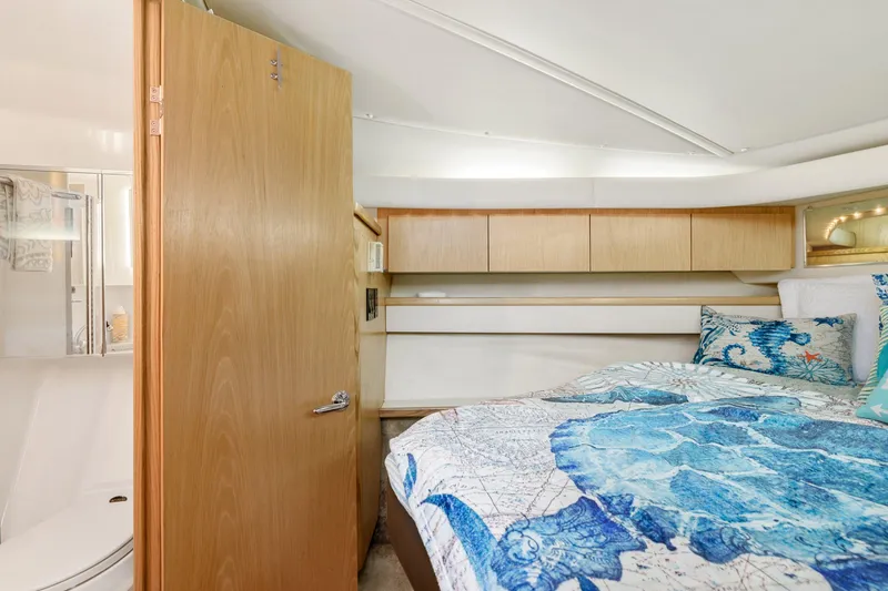  Yacht Photos Pics 1999 Tiara Yachts 4000 Express cabin with bed, wooden cabinets, and bathroom.