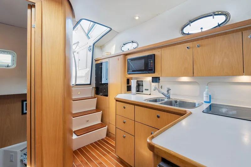  Yacht Photos Pics 1999 Tiara Yachts 4000 Express interior kitchen with wooden cabinetry and modern appliances.