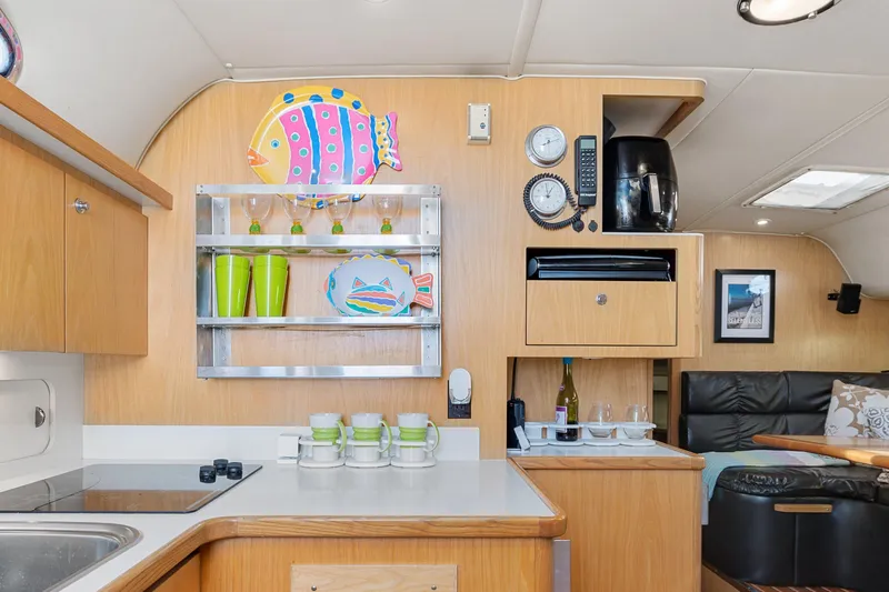  Yacht Photos Pics 1999 Tiara Yachts 4000 Express kitchen with wooden cabinetry and colorful decor.