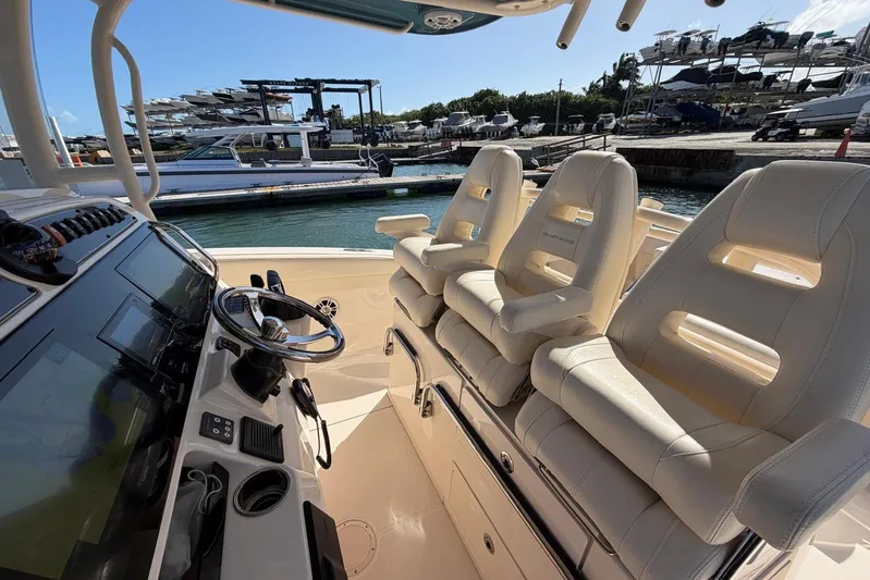  Yacht Photos Pics 2021 Grady-White Canyon 326 boat interior with helm and seating at marina.