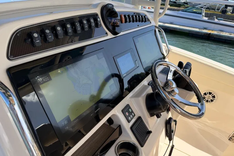  Yacht Photos Pics Control panel of 2021 Grady-White Canyon 326 boat with navigation screens and steering wheel.