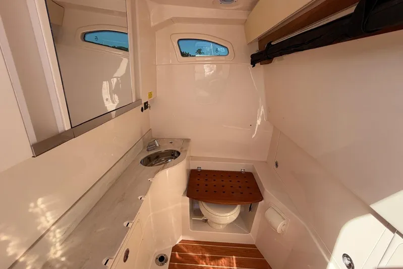  Yacht Photos Pics 2021 Grady-White Canyon 326 boat interior with sink, toilet, and wooden accents.
