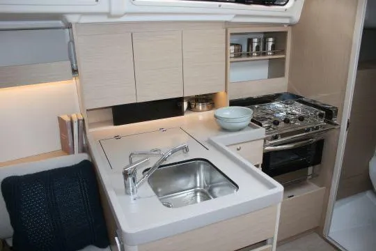 Yacht Photos Pics 2023 Beneteau Oceanis 34.1 yacht kitchen with modern sink, stove, and storage.