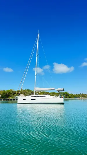  Yacht Photos Pics 2023 Beneteau Oceanis 34.1 sailboat on calm water under clear blue sky.