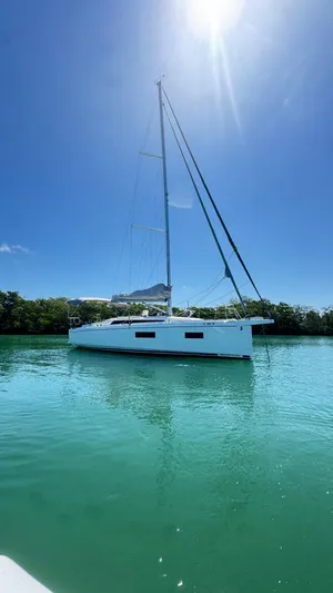  Yacht Photos Pics 2023 Beneteau Oceanis 34.1 sailboat on calm turquoise water under clear blue sky.