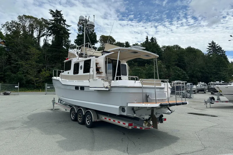  Yacht Photos Pics 2025 Ranger Tugs R-31 CB boat on trailer, parked outdoors with trees in background.