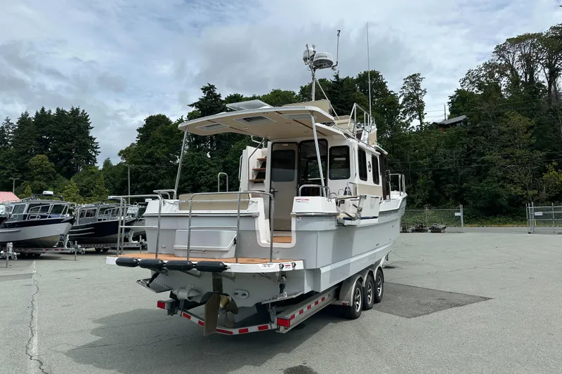  Yacht Photos Pics 2025 Ranger Tugs R-31 CB boat on trailer, parked outdoors with trees in background.