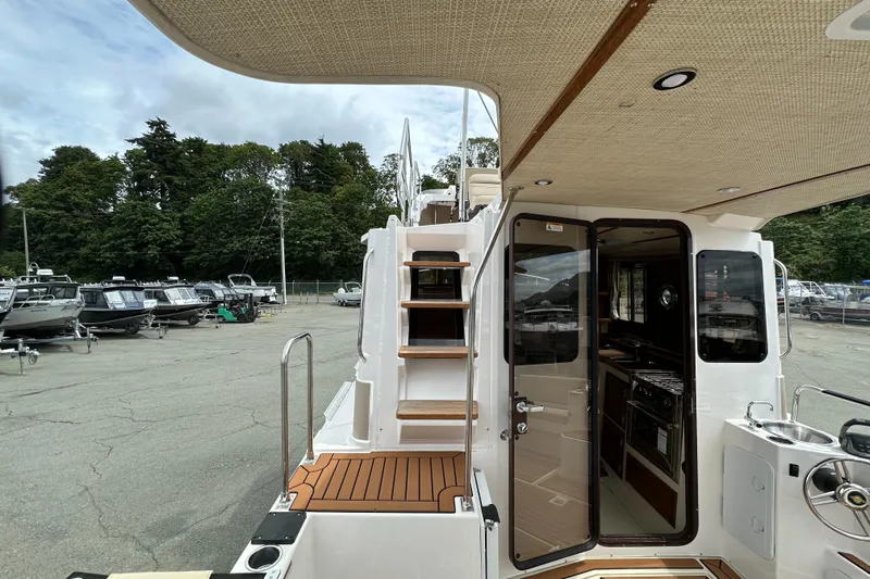  Yacht Photos Pics 2025 Ranger Tugs R-31 CB boat interior with stairs and kitchenette, docked outdoors.